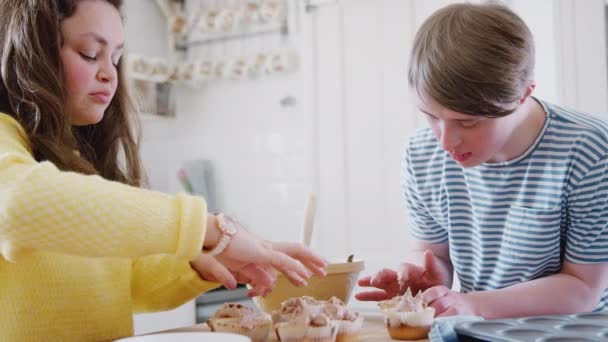 Junges Syndrom Paar Backt Hause Der Küche Cupcakes Mit Zuckerguss — Stockvideo