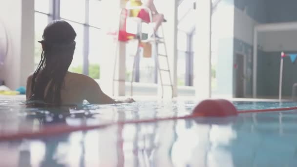 Kapalı Havuzda Yüzen Kadının Sualtı Görüntüsü Ağır Çekimde Çekilmiş — Stok video