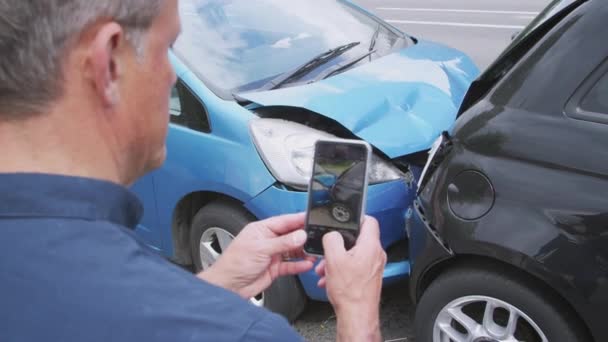 自動車事故に巻き込まれた男性ドライバーが携帯電話で保険金請求の損害を写真に撮る スローモーションで撮影 — ストック動画