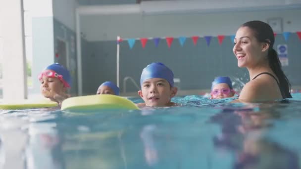 Γυναίκα Προπονητής Στο Νερό Δίνοντας Στα Παιδιά Μαθήματα Κολύμβησης Στην — Αρχείο Βίντεο