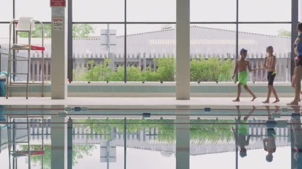 Female Coach Walks Children Swimming Class Edge Pool Camera Shot — Stock Video
