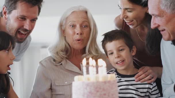 マルチ世代の家族の歌幸せな誕生日に祖母に自宅で彼女は誕生日ケーキのろうそくを吹きます スローモーションで撮影 — ストック動画