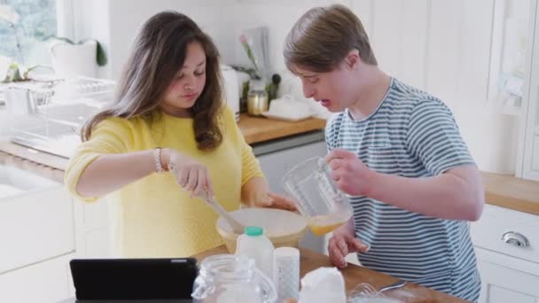 Jovens Downs Síndrome Casal Cozinha Casa Seguindo Receita Comprimido Digital — Vídeo de Stock