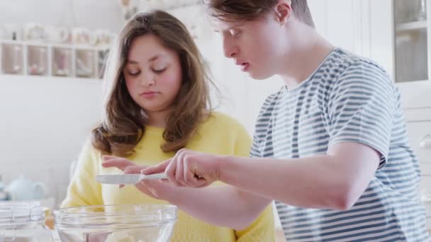 Jovens Downs Síndrome Casal Cozinha Casa Medindo Manteiga Para Receita — Vídeo de Stock