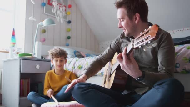 Alleinerziehender Vater Spielt Akustikgitarre Mit Sohn Schlafzimmer Hause Während Schlagzeug — Stockvideo