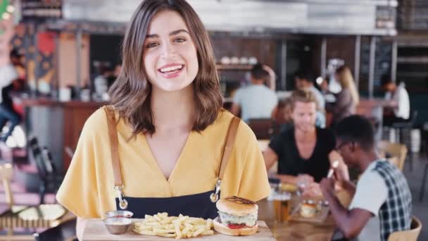 Portrait Waitress Holding Tray Burger Fries Busy Bar Restaurant Shot — Stock Video