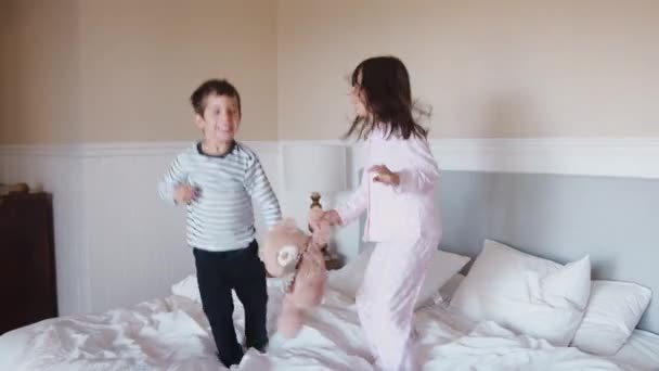 Erkek Kız Kardeş Evde Ebeveyn Yatağında Ağır Çekimde Zıplarken Eğleniyorlar — Stok video