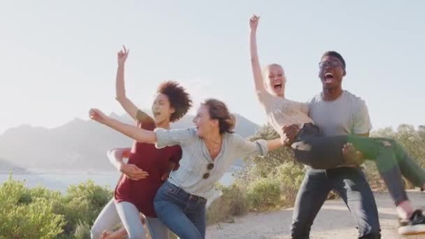 Homens Levantando Mulheres Como Grupo Jovens Amigos Relaxar Contra Sol — Vídeo de Stock