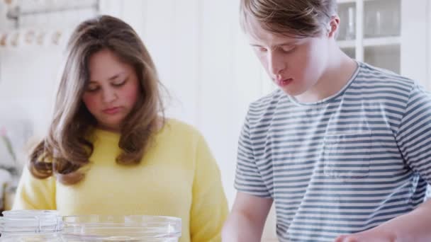 年轻的唐氏综合症夫妇在家里厨房里一起量黄油做蛋糕配方 慢镜头拍摄 — 图库视频影像