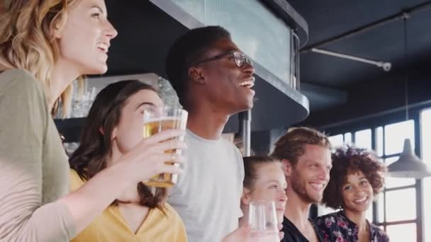 バーでスポーツイベントを見てビールを飲む友人のグループとお祝い スローモーションで撮影 — ストック動画