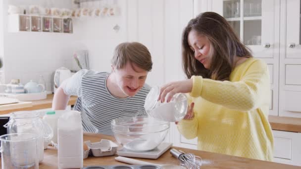 Jovens Downs Síndrome Casal Cozinha Casa Medindo Ingredientes Para Assar — Vídeo de Stock