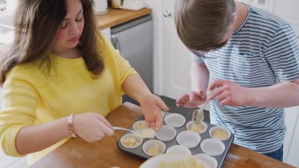 年轻唐氏综合症夫妇在家厨房里烘烤 把混合物放进纸杯蛋糕盒里 慢镜头拍摄 — 图库视频影像