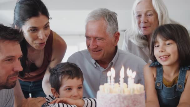 マルチ世代の家族の歌幸せな誕生日に祖父に自宅で彼は誕生日ケーキにろうそくを吹きます スローモーションで撮影 — ストック動画