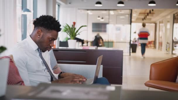 Бизнесмен Сидящий Диване Работающий Ноутбуке Общем Офисе Снимается Замедленной Съемке — стоковое видео