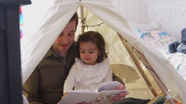 单身父亲在卧室的帐篷里给女儿读书 动作缓慢 — 图库视频影像