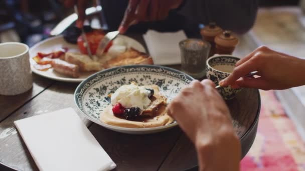 伝統的な英語の休日のホテルでテーブルに座っているカップルの終わり調理された朝食と果物とパンケーキを食べる — ストック動画