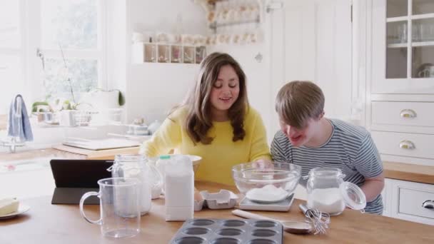 Jovens Downs Síndrome Casal Cozinha Casa Seguindo Receita Comprimido Digital — Vídeo de Stock