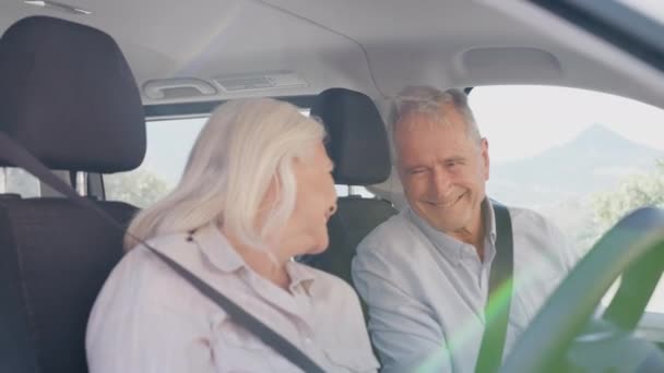 シニアカップルは車に座って 休日の目的地にドライブとしてカメラで笑顔 スローモーションで撮影 — ストック動画