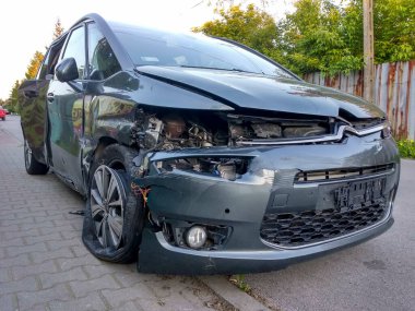 Kazadan sonra siyah araba. Yoldaki kırık araba. Bir kaza sonucu arabanın gövdesi hasar görmüş.. 