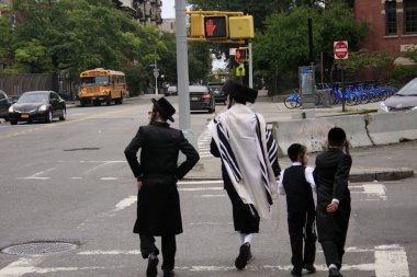 New York, ABD - 3 Eylül 2016. Williamsburg 'da Yahudi mahallesinde din kıyafetleriyle yürüyen insanlar.