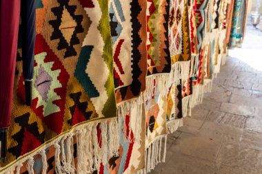 Kafkas desenli ulusal halılar eski kasabada eski taşların üzerinde satılıktır.