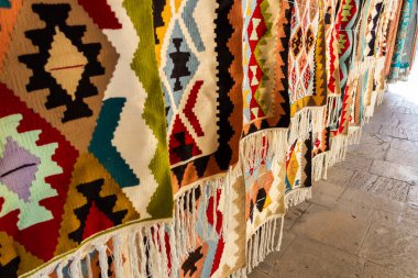 Kafkas desenli ulusal halılar eski kasabada eski taşların üzerinde satılıktır.