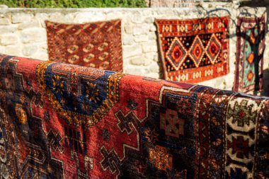 Kafkas desenli ulusal halılar eski kasabada eski taşların üzerinde satılıktır.