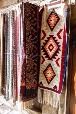 Kafkas desenli ulusal halılar eski kasabada eski taşların üzerinde satılıktır.