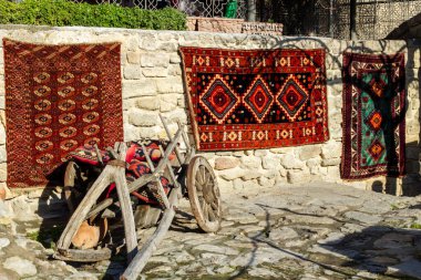 Kafkas desenli ulusal halılar eski kasabada eski taşların üzerinde satılıktır.