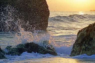 Akşam okyanus. Dalgaların üzerinde gün batımı. Bulutlar ve akşam gökyüzünün parlak renkleri.                               