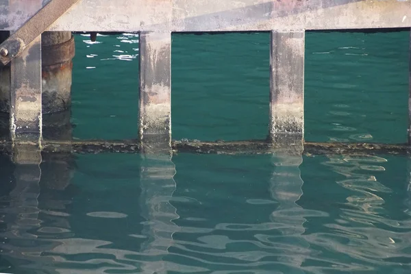 Los Soportes Amarre Reflejan Superficie Del Agua Olas Resplandor Luz —  Fotos de Stock