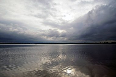      Lepel Gölü 'nde bulutlu bir gün. Kara yağmur bulutları ve su yüzeyindeki yansıma. Ufuk ve boşluk.                          