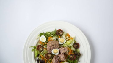 Beyaz masa arka plan doğal ışık seçici odak üzerinde yaşam için sağlıklı gıda sebze taze ve hafif Tuna et salatası marul, yumurta ve domates doğranmış