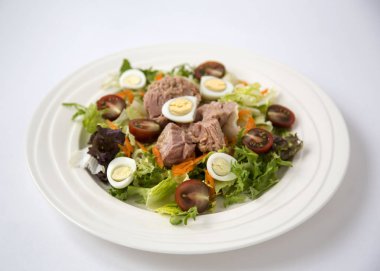 Beyaz masa arka plan doğal ışık seçici odak üzerinde yaşam için sağlıklı gıda sebze taze ve hafif Tuna et salatası marul, yumurta ve domates doğranmış