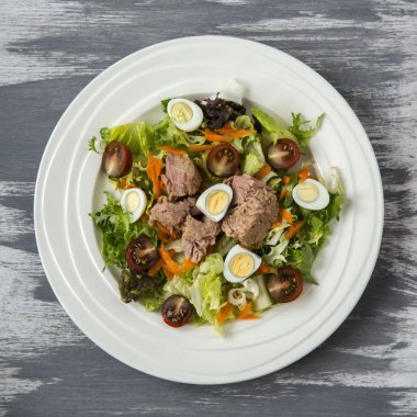 Ahşap boyalı arka plan doğal ışık seçici odak üzerinde yaşam için sağlıklı gıda sebze taze ve hafif Tuna et salatası marul, yumurta ve domates doğranmış