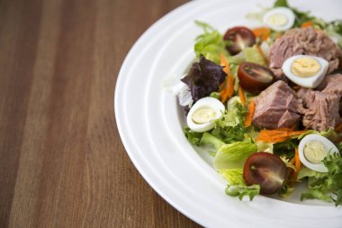 Ahşap arka plan doğal ışık seçici odak üzerinde yaşam için sağlıklı gıda sebze taze ve hafif Tuna et salatası marul, yumurta ve domates doğranmış