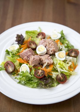 Ahşap arka plan doğal ışık seçici odak üzerinde yaşam için sağlıklı gıda sebze taze ve hafif Tuna et salatası marul, yumurta ve domates doğranmış