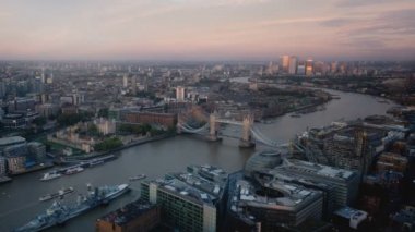 zaman atlamalı Londra manzarası ile ışıklı Tower bridge ve Canary Wharf günbatımı zamanı, İngiltere