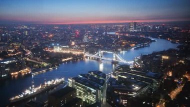 zaman atlamalı Londra manzarası ile ışıklı Tower bridge ve Canary Wharf gündoğumu zaman, İngiltere