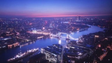 zaman atlamalı Londra manzarası ile ışıklı Tower bridge ve Canary Wharf gündoğumu zaman, İngiltere
