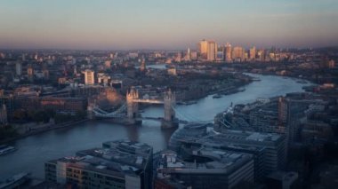 zaman atlamalı Londra manzarası ile ışıklı Tower bridge ve Canary Wharf günbatımı zamanı, İngiltere