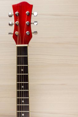 Gitar Akustik kırmızı, boyun bir ahşap açık renkli klasik İspanyol, müzikal okula klavye ve dizeleri, çocuklar ve yetişkinler yakın çekim için oyun enstrümanın mikrofondaki aittir.