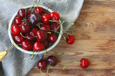 kevgir ile olgun tatlı kiraz, ahşap masa, üstten görünüm üzerinde tuval havlu ıslak