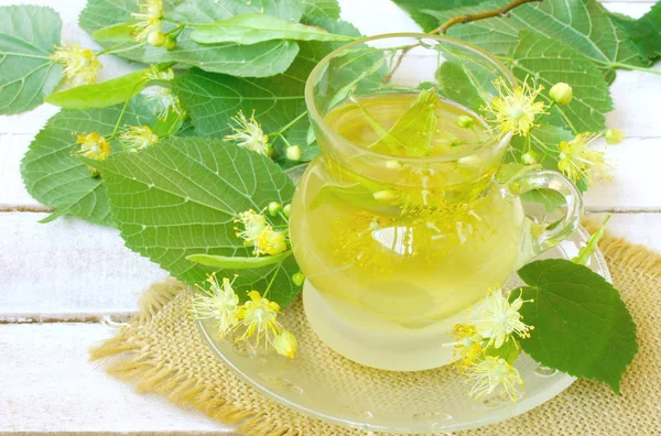 Cam bardak ıhlamur çayı, ıhlamur closeup beyaz tahta masaya çiçek ile şubeleri