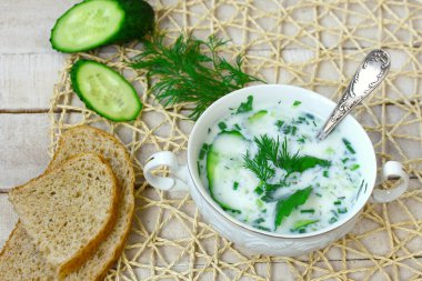 soğuk yoğurt çorbası ile salatalık, otlar ve sarımsak ahşap masa üzerinde beyaz kase