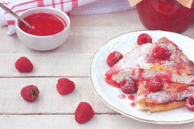 Beyaz tabak, ahududu meyveleri rustik tarzı ahşap bir masaya ahududu ile süzme peynir güveç parçaları jam