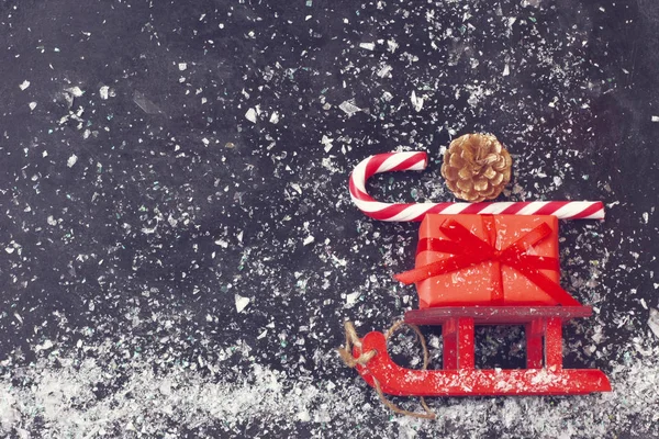 Červené Vánoční Sáně Nošení Krabičky Zlatý Kužel Pruhované Cukroví Černý — Stock fotografie