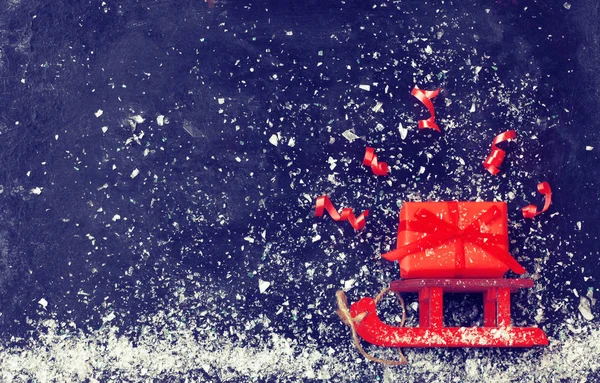 Різдвяні Червоні Санки Несуть Подарункову Коробку Змій Чорній Поверхні Снігопад Ліцензійні Стокові Зображення