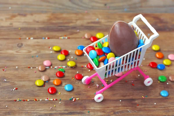 Easter chocolate egg, colorful candy on wooden table. Easter sal — Stock Photo, Image