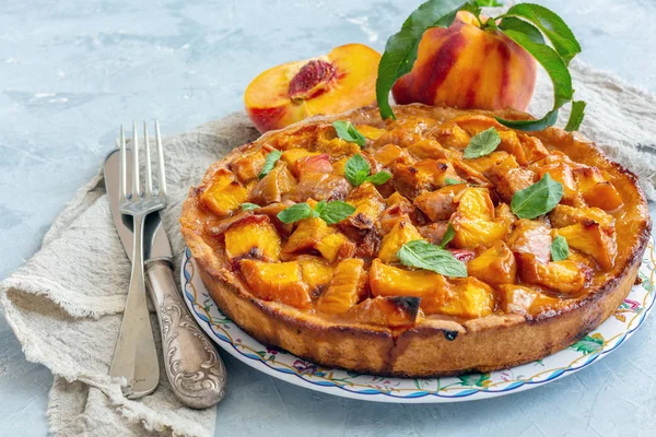 Dish with traditional fruit pie and cutlery on textured concrete background.